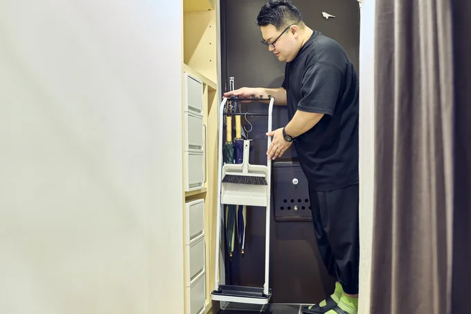 玄関で使うほうきやちり取りは、傘ハンガーにつるして収納。