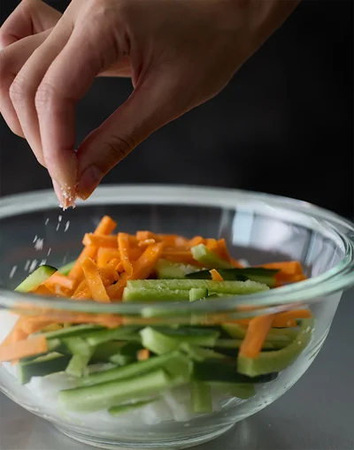 細切りにした野菜をボウルに入れて塩をまぶす。