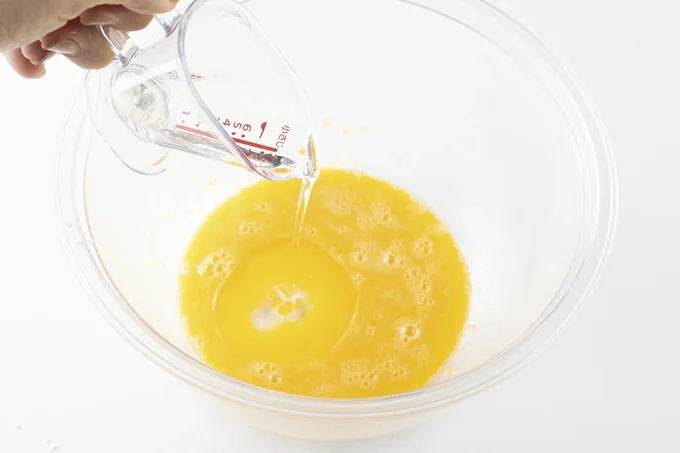 水、卵黄、粉砂糖、練乳を入れて泡立て器でよく混ぜる