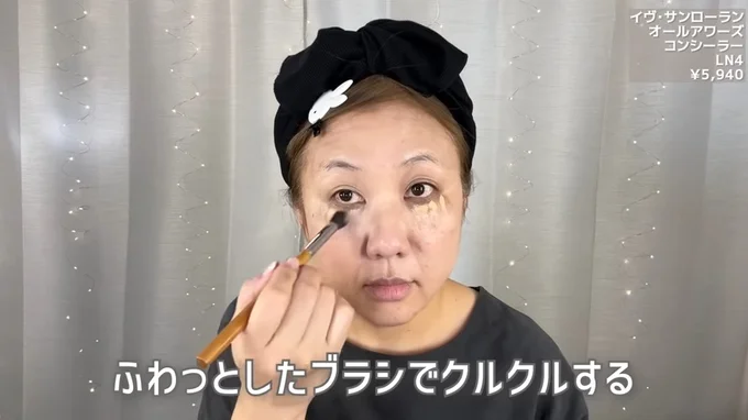 ベージュのコンシーラーを目元に乗せ、ブラシでくるくると伸ばす