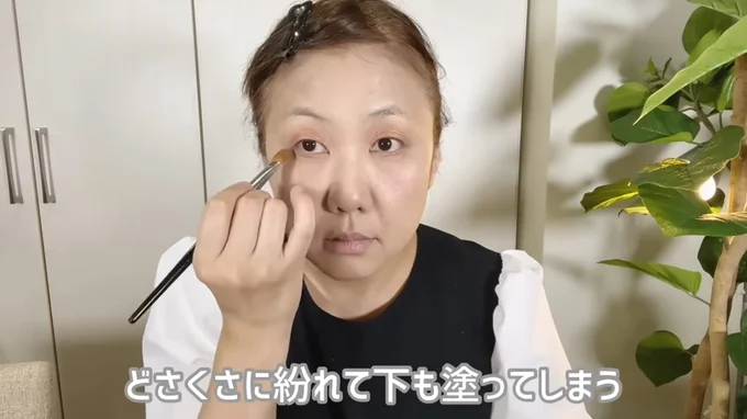 オレンジ色のパウダーアイシャドウを重ねる。下まぶたにもブラシで塗っていく