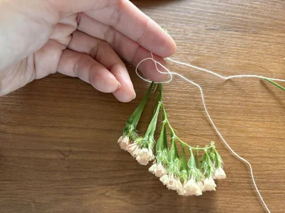 お花を糸で少しずつ結んでつなげていきます