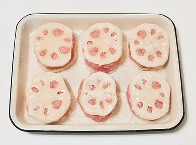 【作り方2】輪切りにしたれんこんの両面に片栗粉をまぶし、1のタネをはさんで形を整える。同じものを6個作る。