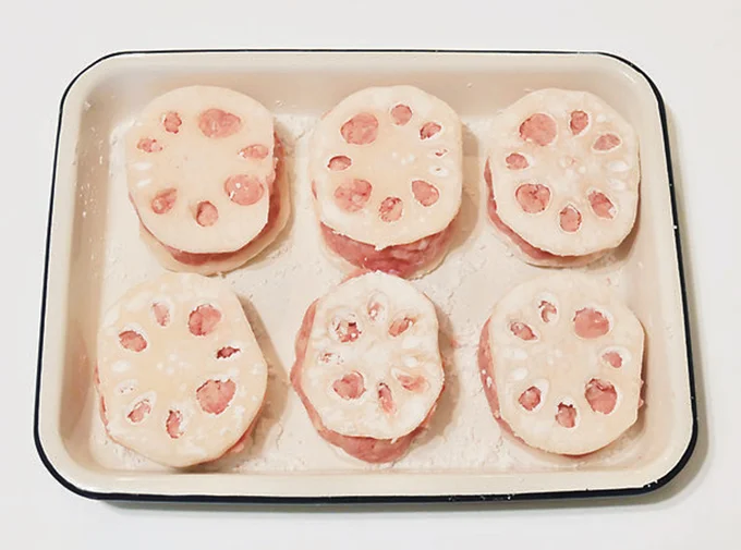【作り方2】輪切りにしたれんこんの両面に片栗粉をまぶし、1のタネをはさんで形を整える。同じものを6個作る。