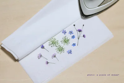 アイロン台や雑誌の上にティッシュ→花→ティッシュの順に重ねます
