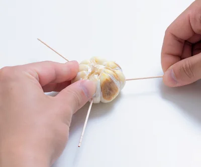2　にんにくの3方向からようじを刺す。（3に続く）
