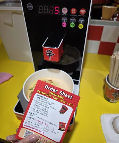 オーダーシートに希望を記載。トッピングを選んだら自動ラーメン調理器へ