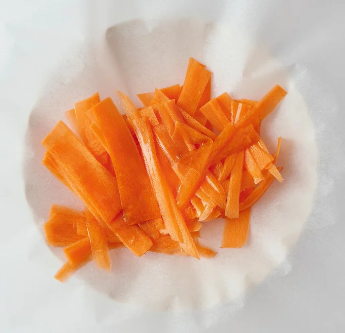 クッキングシートににんじんをのせ、麺つゆをかけて包む