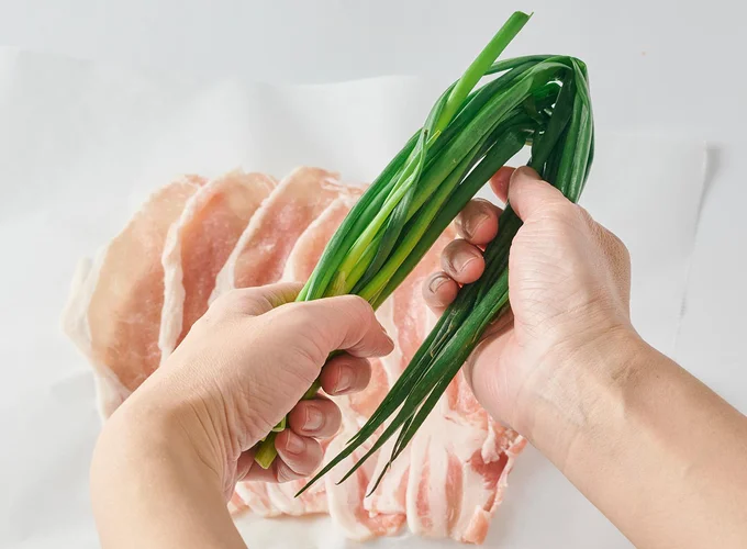 クッキングシートに豚肉を並べて塩こしょうをふる