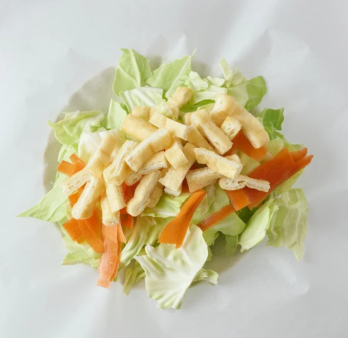 クッキングシートにキャベツ、にんじん、油揚げをのせ、包む
