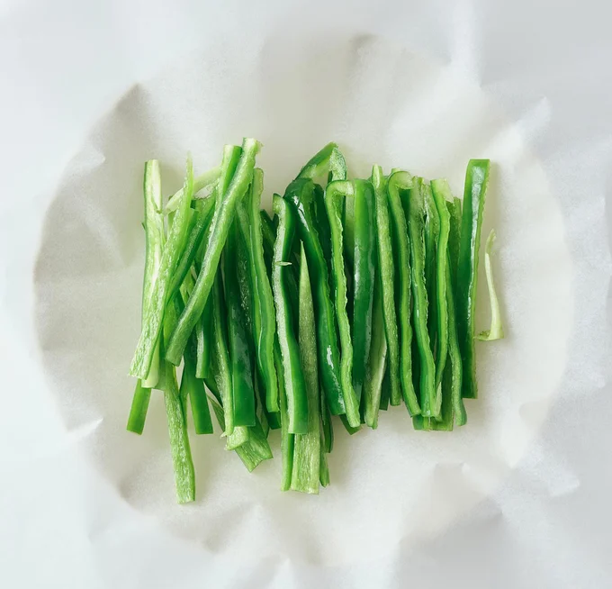 クッキングシートにピーマンをのせ、包む