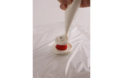 苺の上にもクリームを絞る