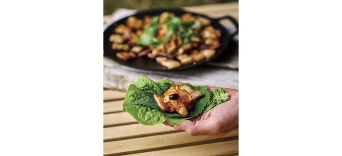 サンチュを広げ、えごまの葉、豚バラ肉、白菜キムチ、九条ねぎをのせて包む