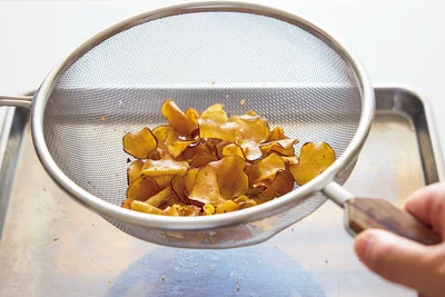 ざるを使ってしっかり油をきると、カリッとかたい食感のチップスに