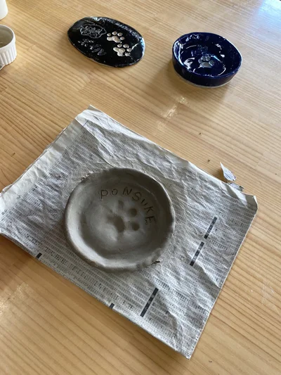肉球アートのお皿を焼く前▶制作中のぽん助ちゃんの様子（⇒次へ）