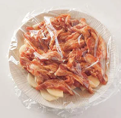 耐熱皿にじゃがいもを広げ、下味をつけた豚肉をおおうようにのせる
