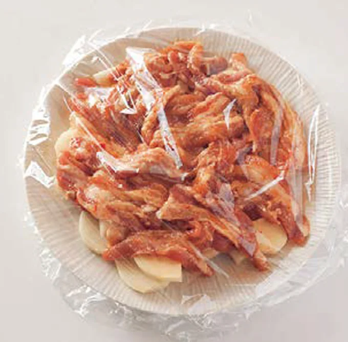 耐熱皿にじゃがいもを広げ、下味をつけた豚肉をおおうようにのせる