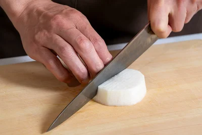 輪切りにした大根の表と裏に、それぞれ縦、横に切り目を入れます。