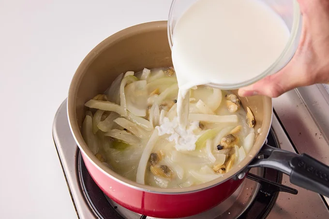 牛乳を加えて弱火で温め、塩こしょうを加える