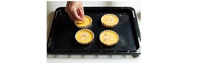 溶かしたバターを加えて混ぜたら、カップに流し入れ、アーモンドスライスをのせる