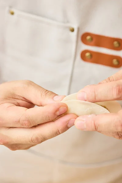 皮の縁に水をつけて半分にたたみ、端からひだを寄せて留める