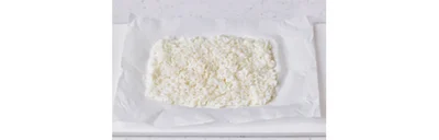 オーブン用ペーパーを20cm長さに切ってご飯をのせ、水でぬらしたスプーンで薄くのばす
