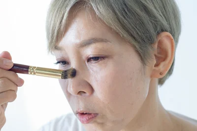 コンシーラーを塗った部分とシワは避け、鼻すじ、ほおの高いところにのみ、ブラシに少量とったハイライトを、肌を磨くようにつけていきます