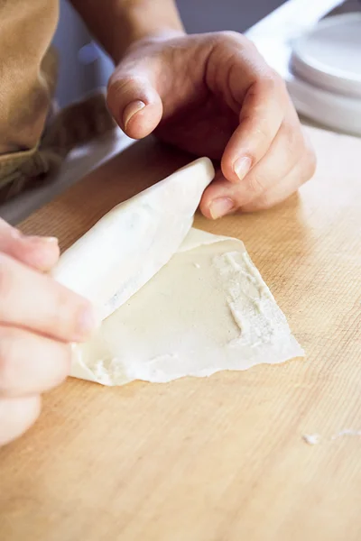 皮の向こう側の縁に水溶き小麦粉適量をぬり、手前からふっくらと巻いて