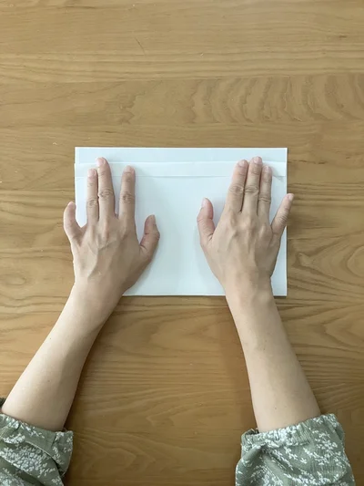 上の紙の上部を2回ほど手前に折る（▶︎次へ）