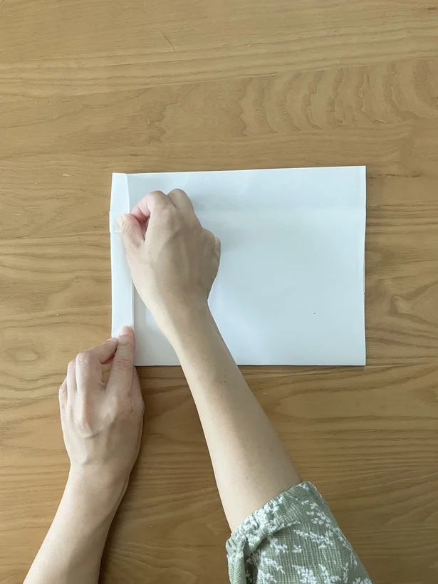 裏返しにして、片側の端を2〜3回ほど折る（▶︎次へ）