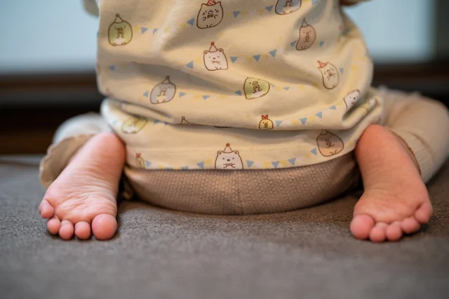 正座する子どもの後ろ姿(⇒次へ)