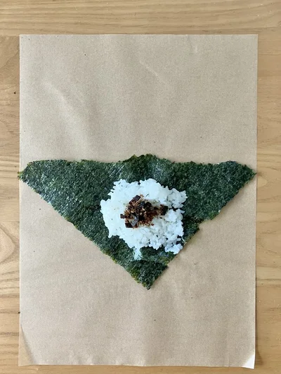 三角形の一番長い辺を上にし、ご飯・具材を乗せる（▶︎次へ）