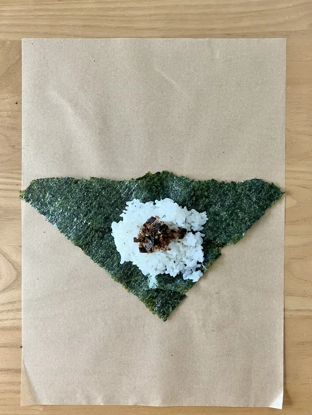 三角形の一番長い辺を上にし、ご飯・具材を乗せる（▶︎次へ）