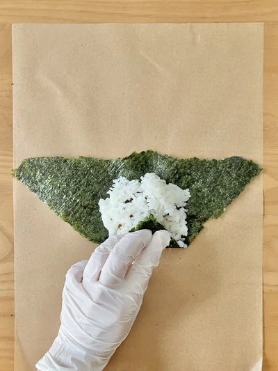 下の角をご飯の真ん中に来るように折り…（▶︎次へ）