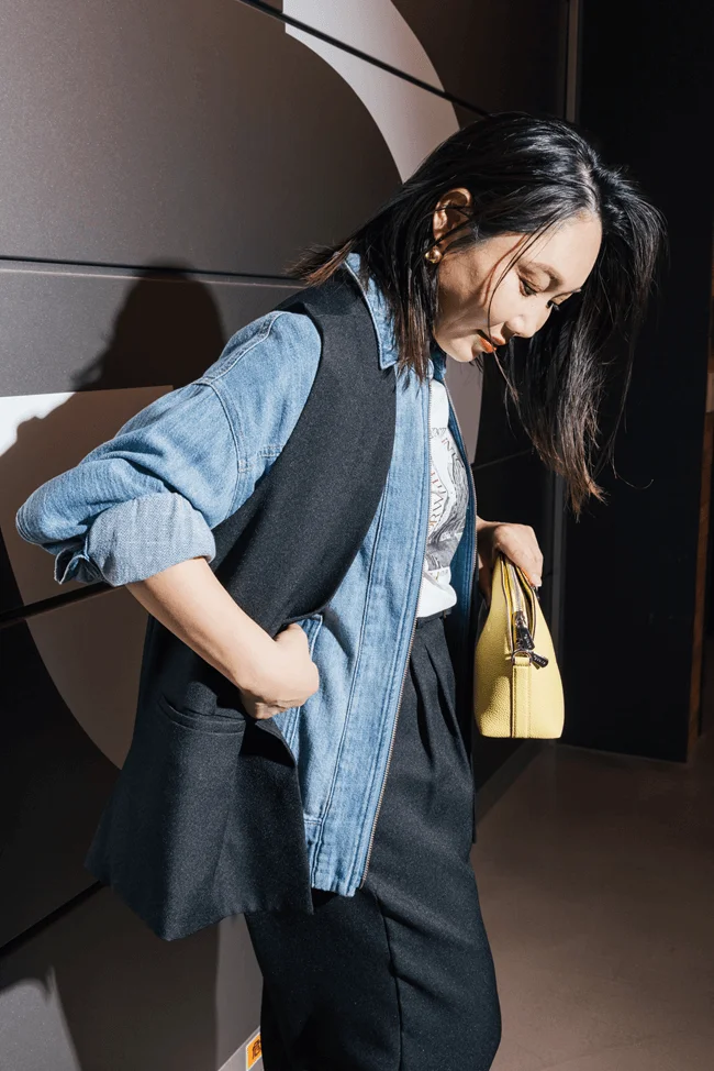 デニムジャケットの上にジレを重ねる大胆なレイヤード