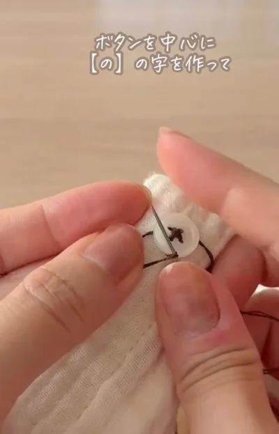 ボタンを中心に「の」の字を書くように糸を回す▶ボタンの下で…（⇒次へ）