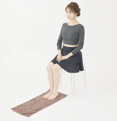  椅子に座り床にタオルを置く