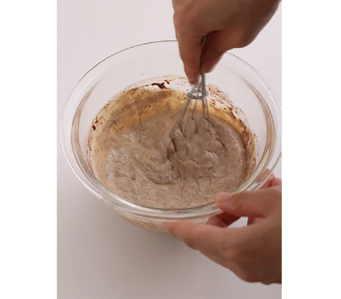 薄力粉とココアパウダーをふるいながら加え、ぐるぐる混ぜる