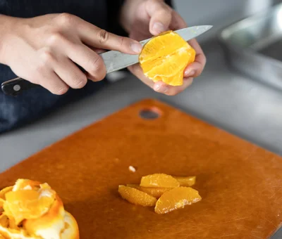 オレンジは、皮をむいてくし形にカット