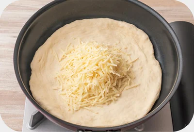 フライパンに生地を入れてのばし、ピザ用チーズをのせる