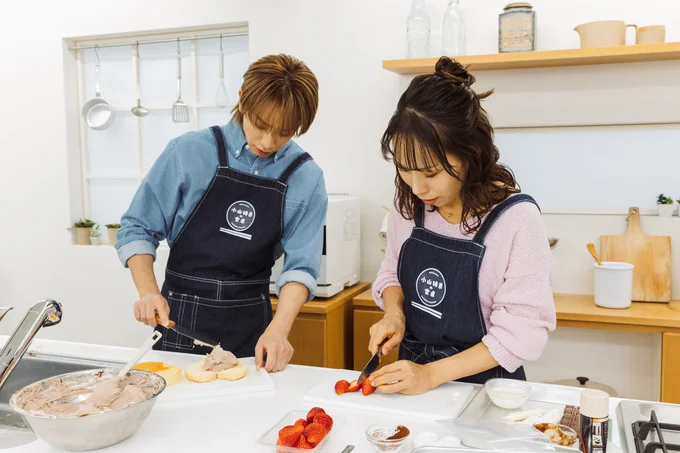 デコレーション用のイチゴをカットする2人