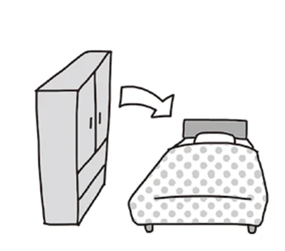 ベッドと背の高い家具が向かい合わせ