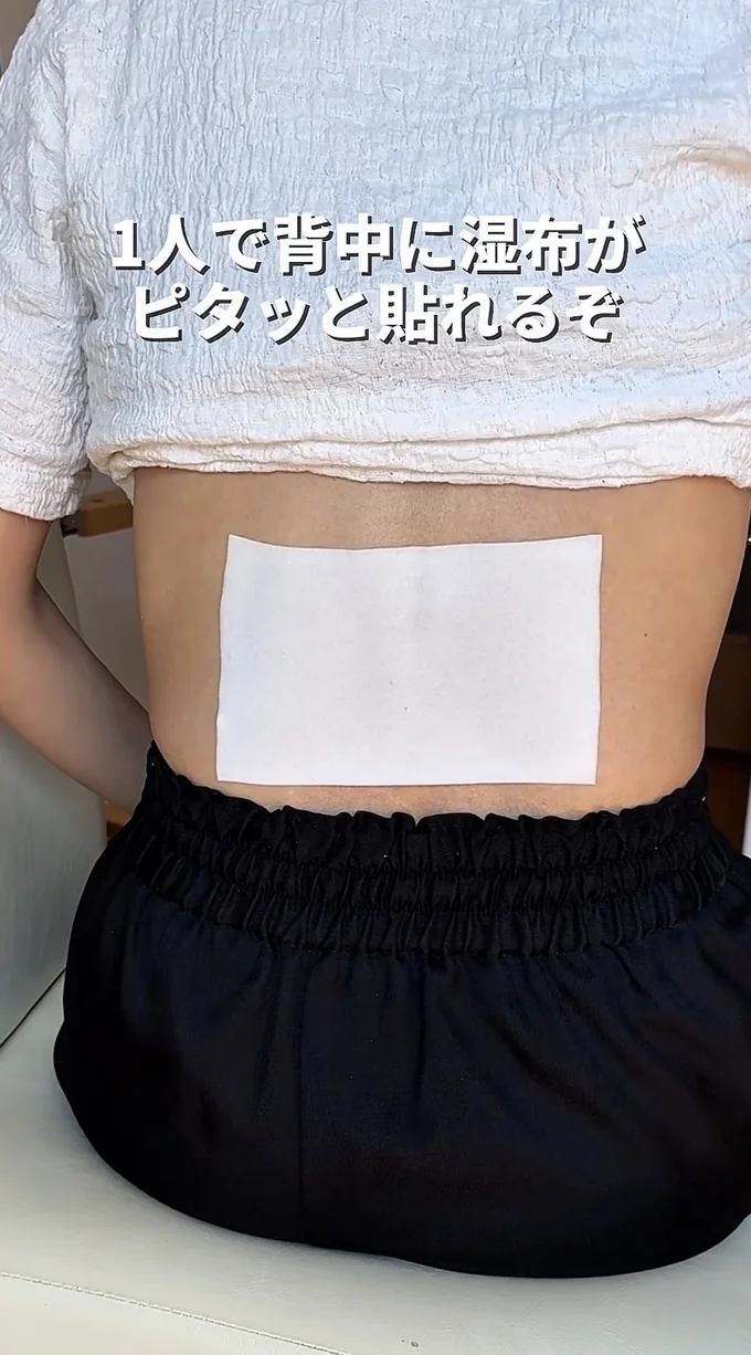 背中に貼られた湿布（⇒次へ）