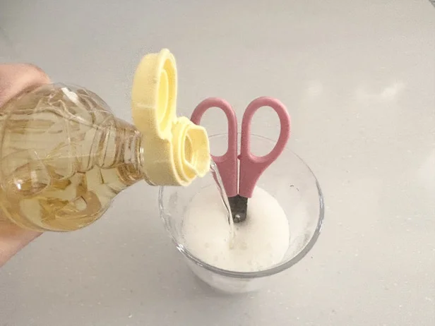 ハサミの刃が隠れる程度の泡が立つよう、お酢を適量注ぎます（▶次へ）