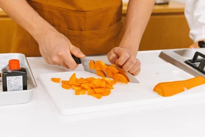 カメラを忘れて真剣にいちょう切りをする小山さん