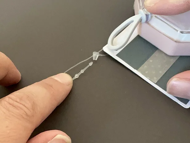 留め具の方へコードを曲げます（▶次へ）