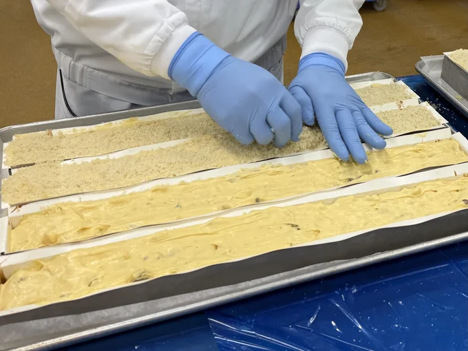 人の手で「シュトロイゼル」をトッピング