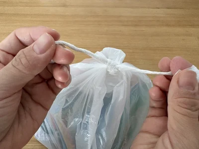 1、2つの持ち手をぐるぐるねじって、細く・固くする。（▶次へ）