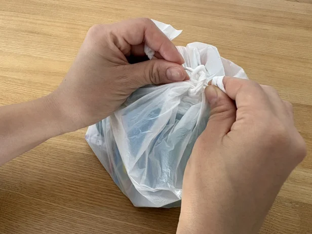 2、持ち手が固くなったら、細くした部分を両方向から結び目に押し込む。（▶次へ）