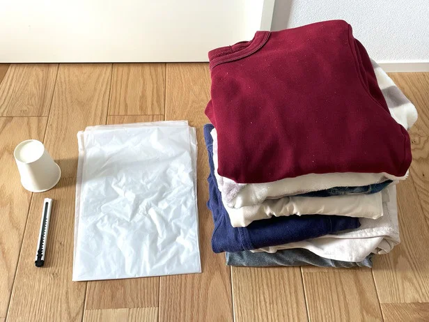 まずは大きめの透明ビニール袋・紙コップ・カッターナイフ・収納したい服を準備（▶次へ）